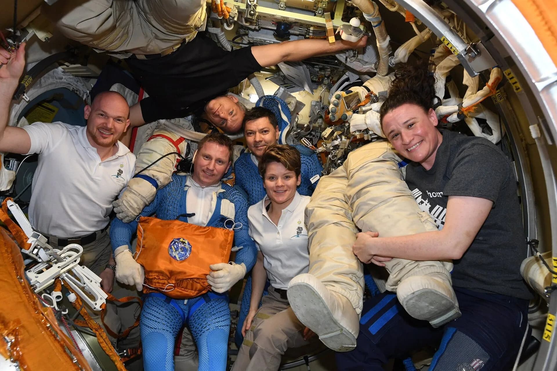 A space station crew gathered inside an airlock