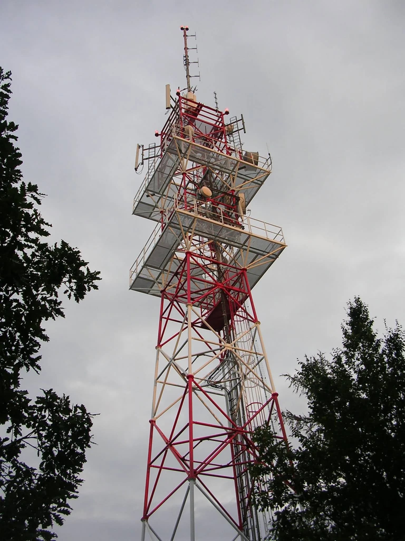 A tall telecommunications tower with antennas against the sky