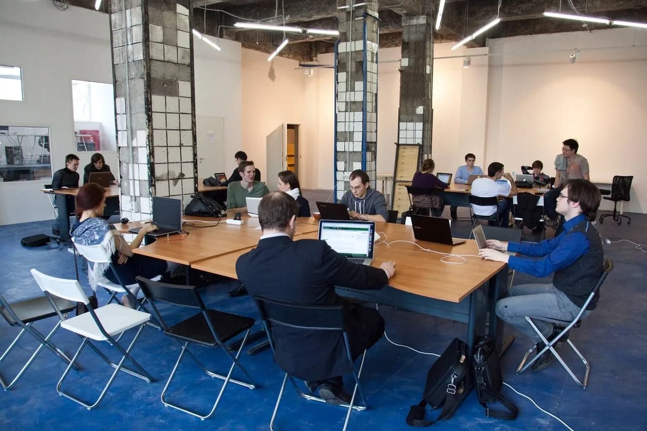 People working on laptops at a shared office table