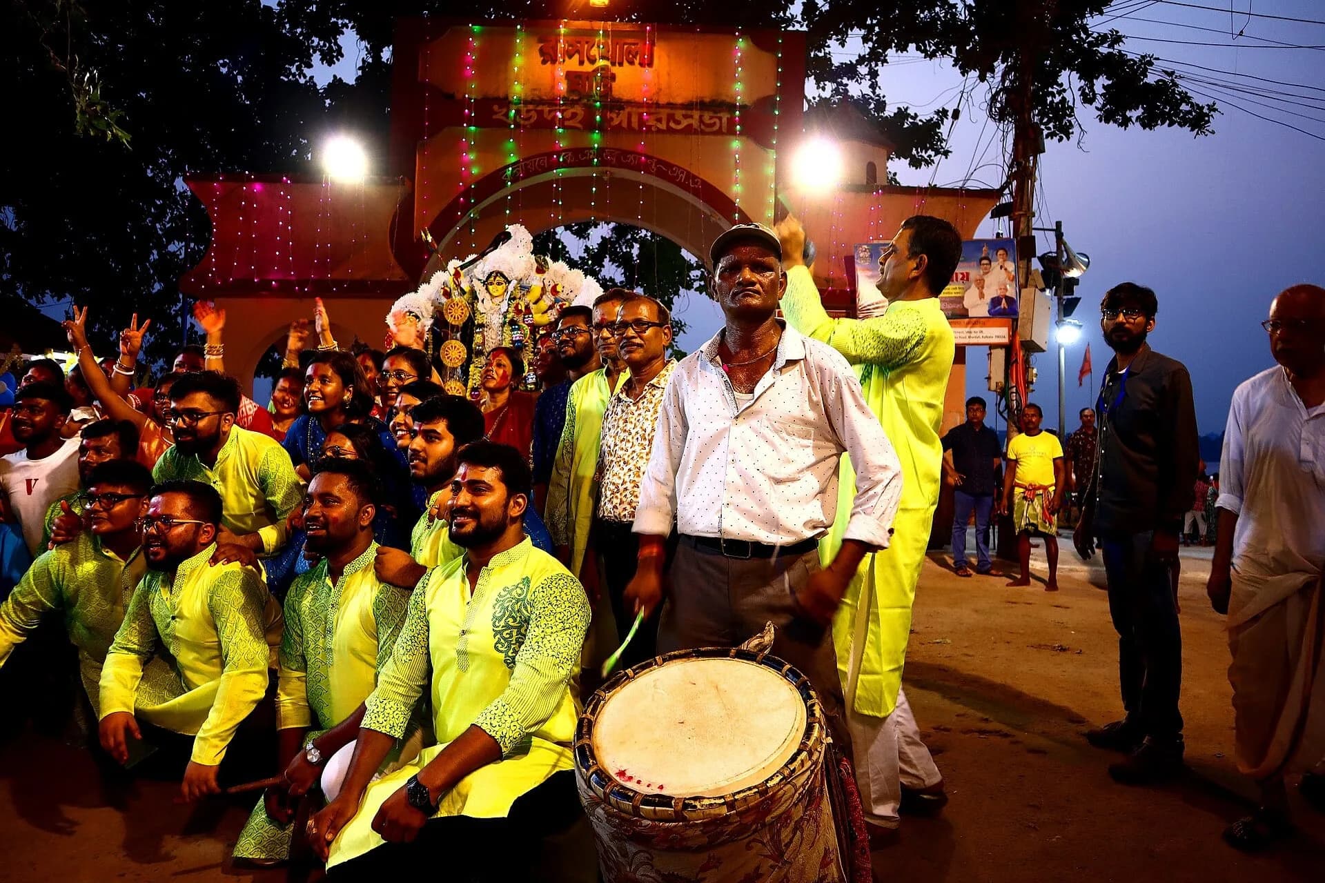 Devotees with drums carrying a decorated idol of Goddess Durga at night