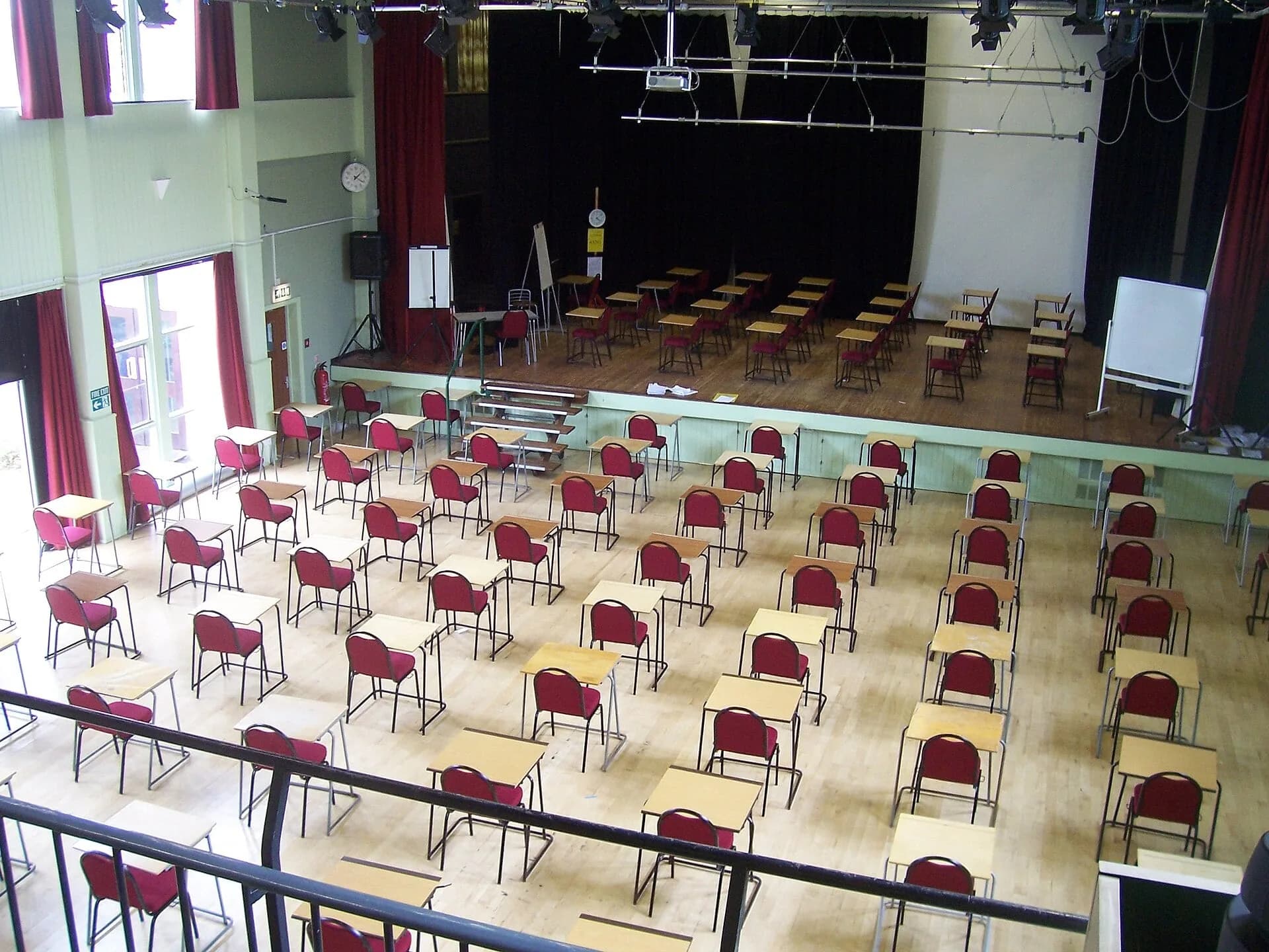 An empty exam hall with rows of desks and chairs