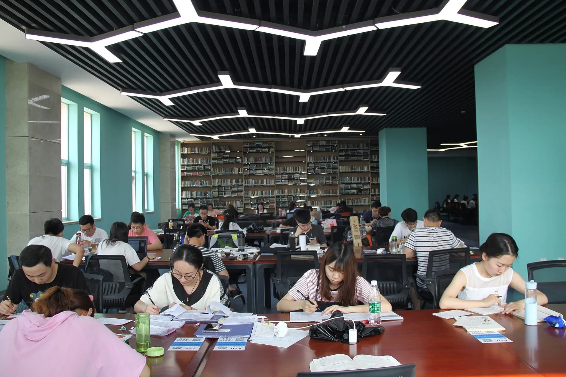 Students studying at long tables in a library