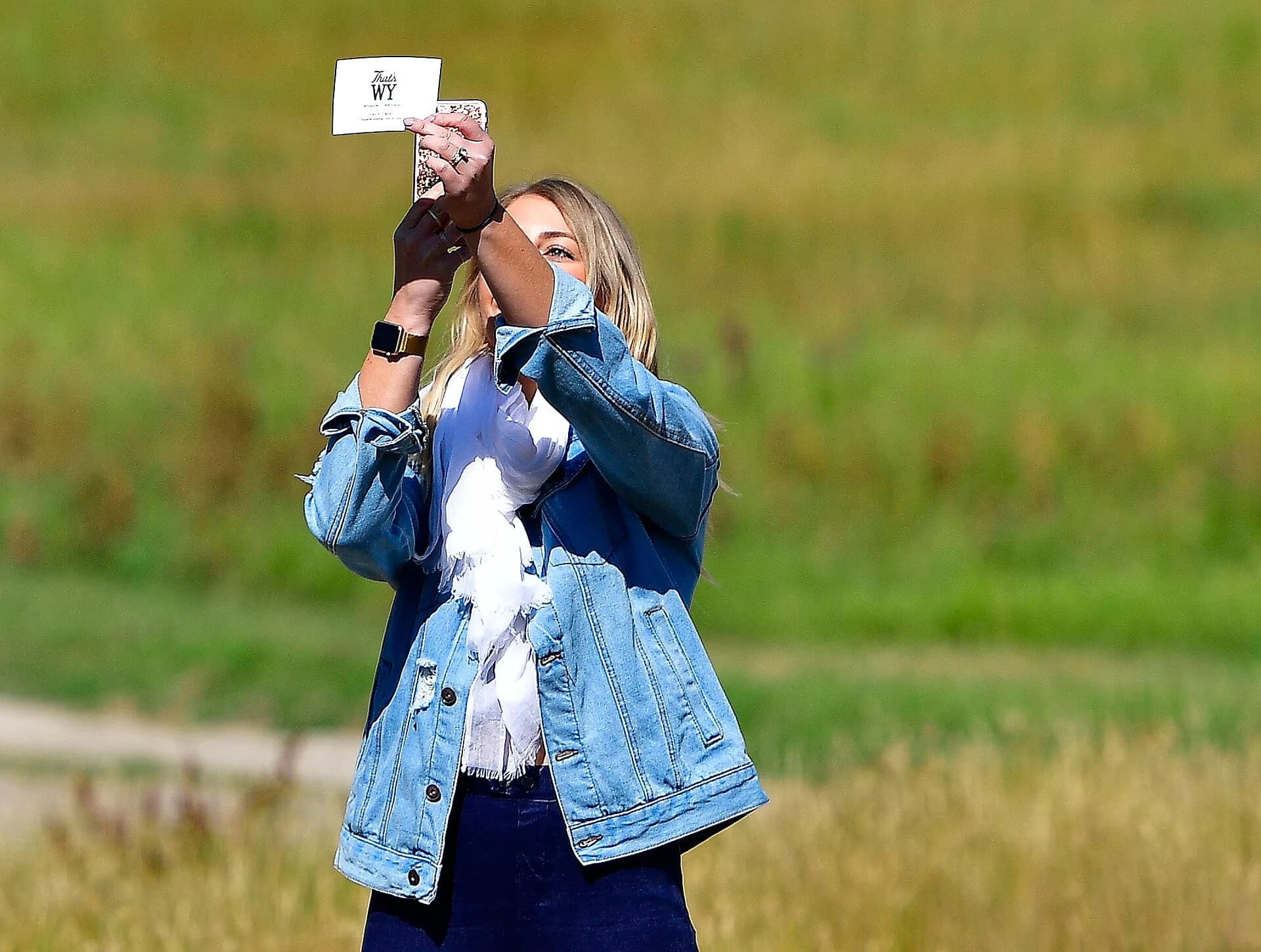 A woman taking a photo with her smartphone outdoors