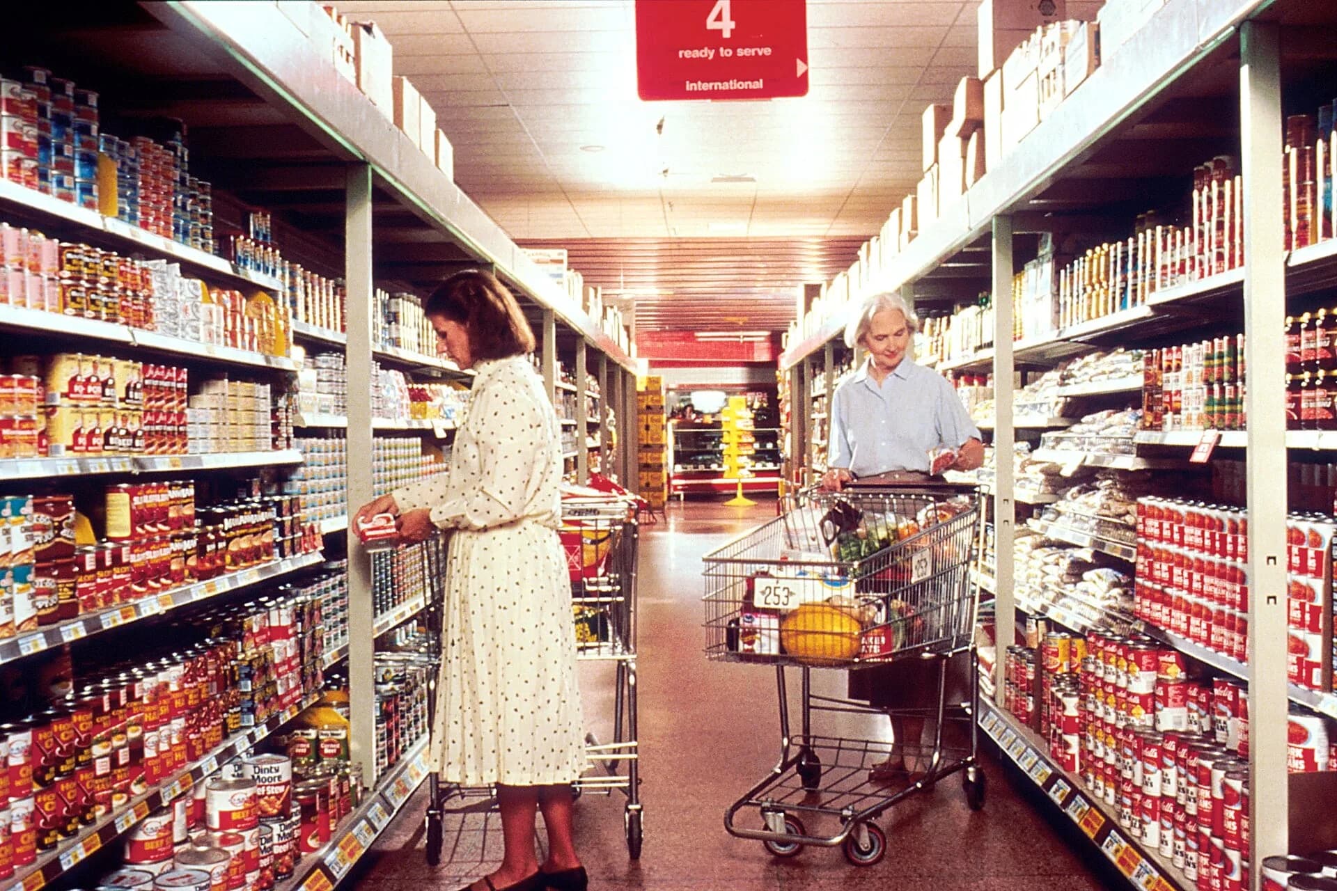 Shoppers pushing trolleys along supermarket aisles