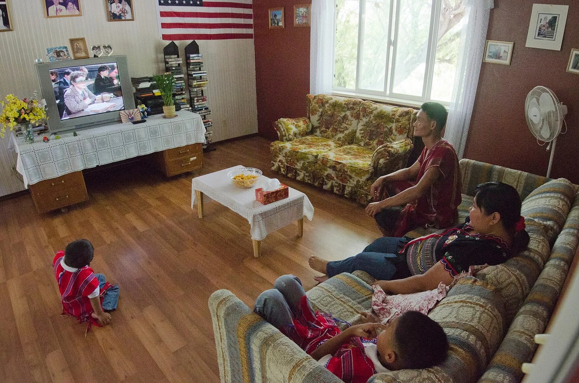 A family relaxing in a living room watching television