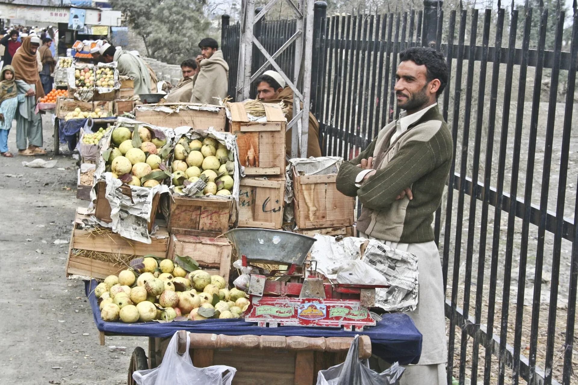 A fruit seller by a border fence in north-west Pakistan