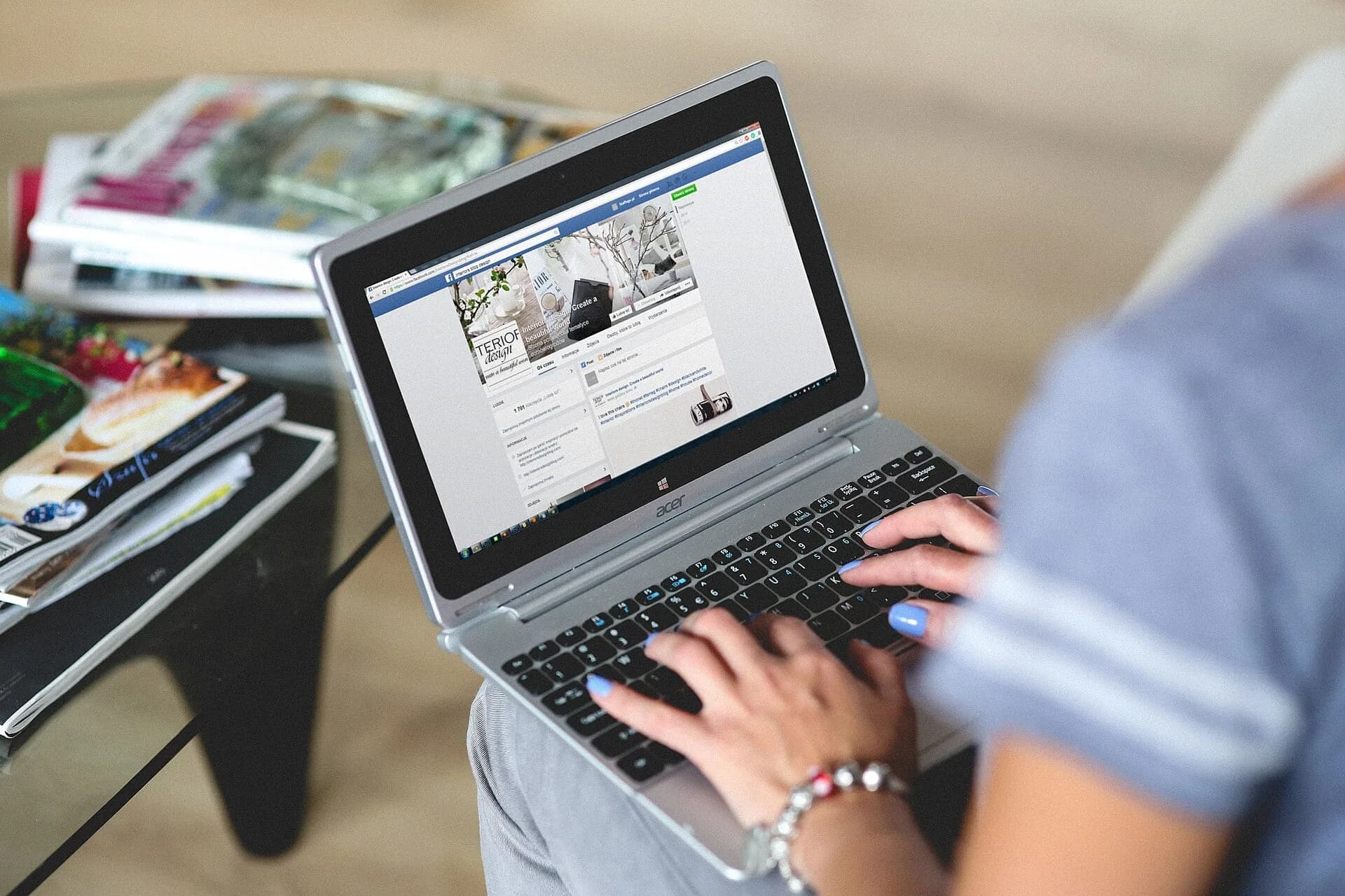 A woman working on a laptop with her hands on the keyboard