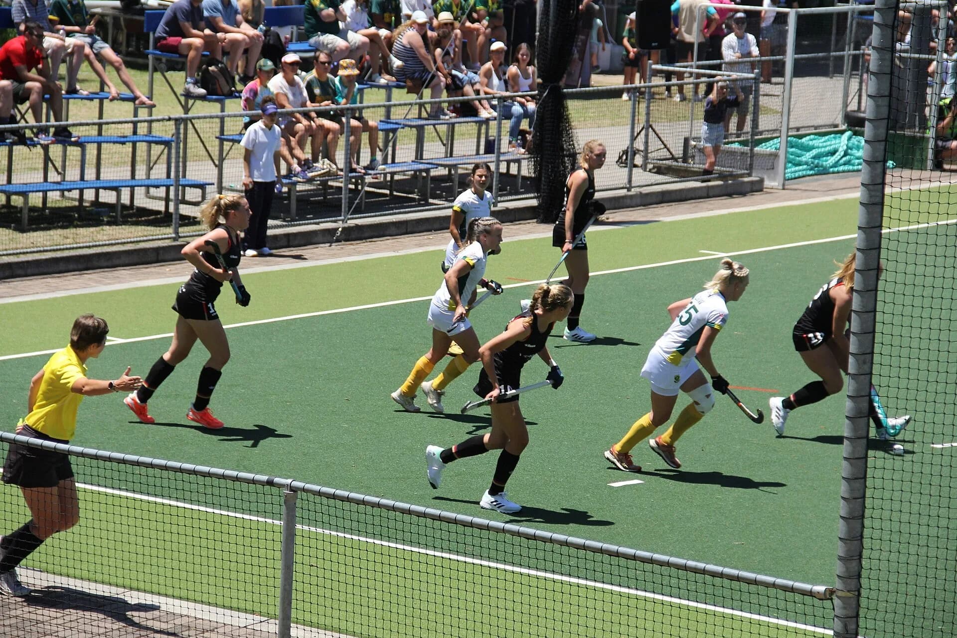 Field hockey players competing for the ball