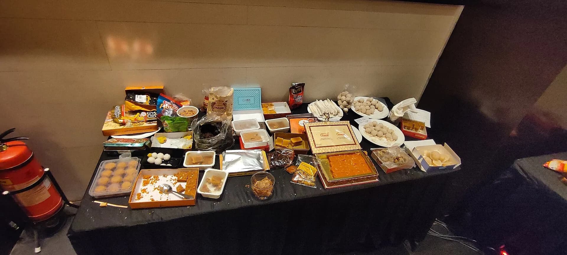 A table laid with boxes of Indian sweets and snacks
