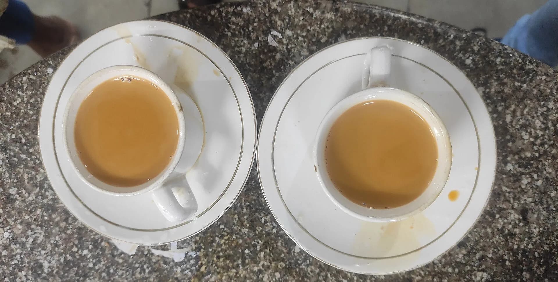 Two cups of milky tea on saucers