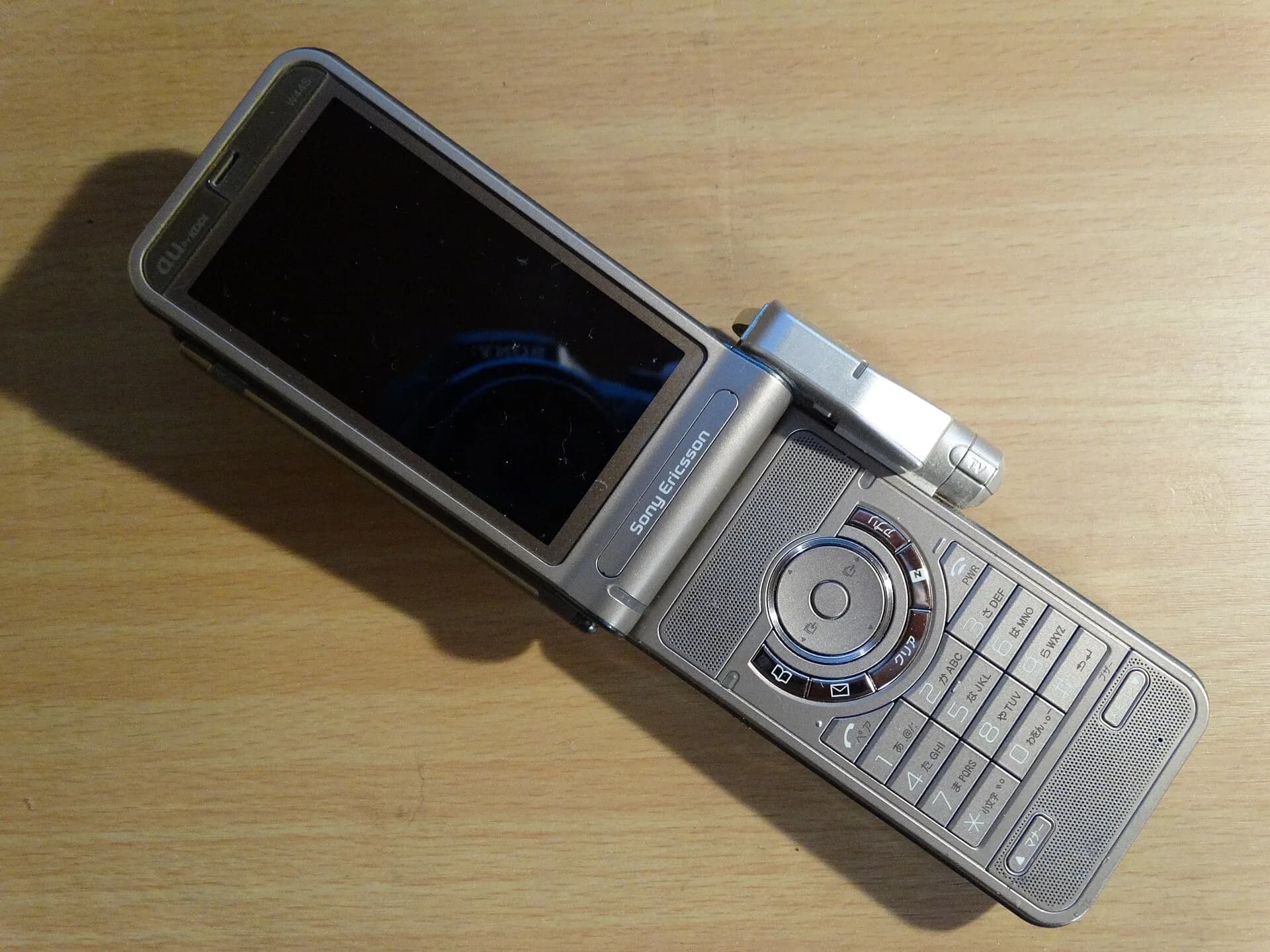 A silver mobile phone on a wooden table
