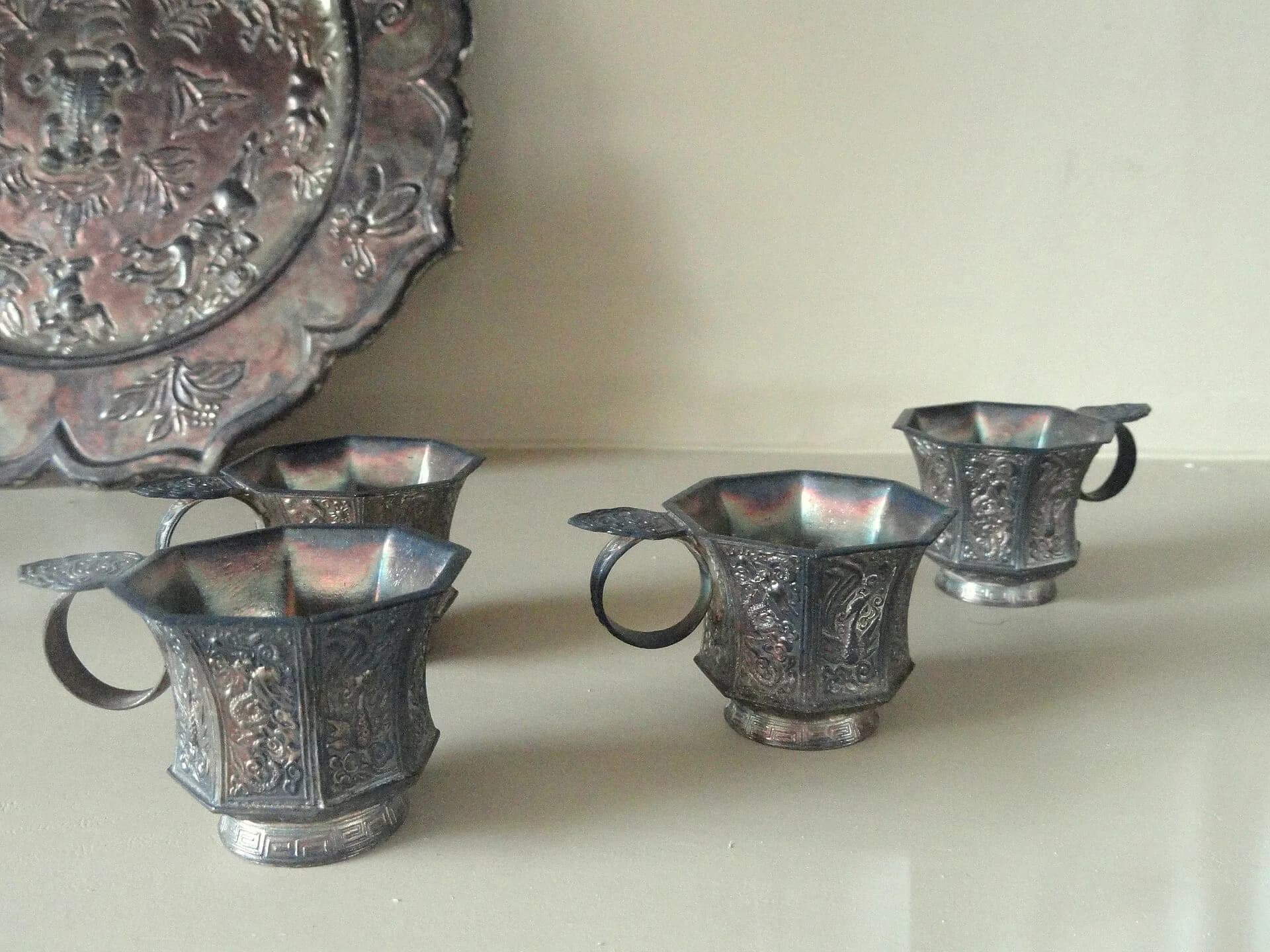 Ornate silver cups and a silver jug