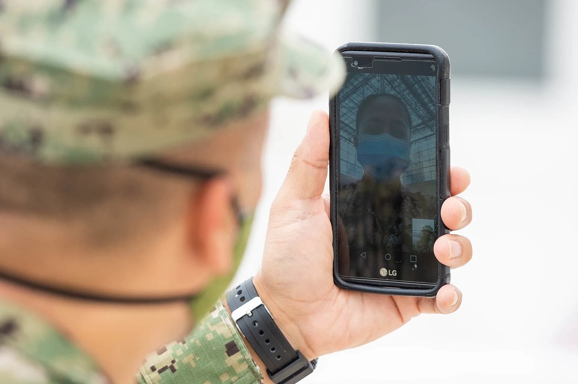 A person in uniform holding a smartphone