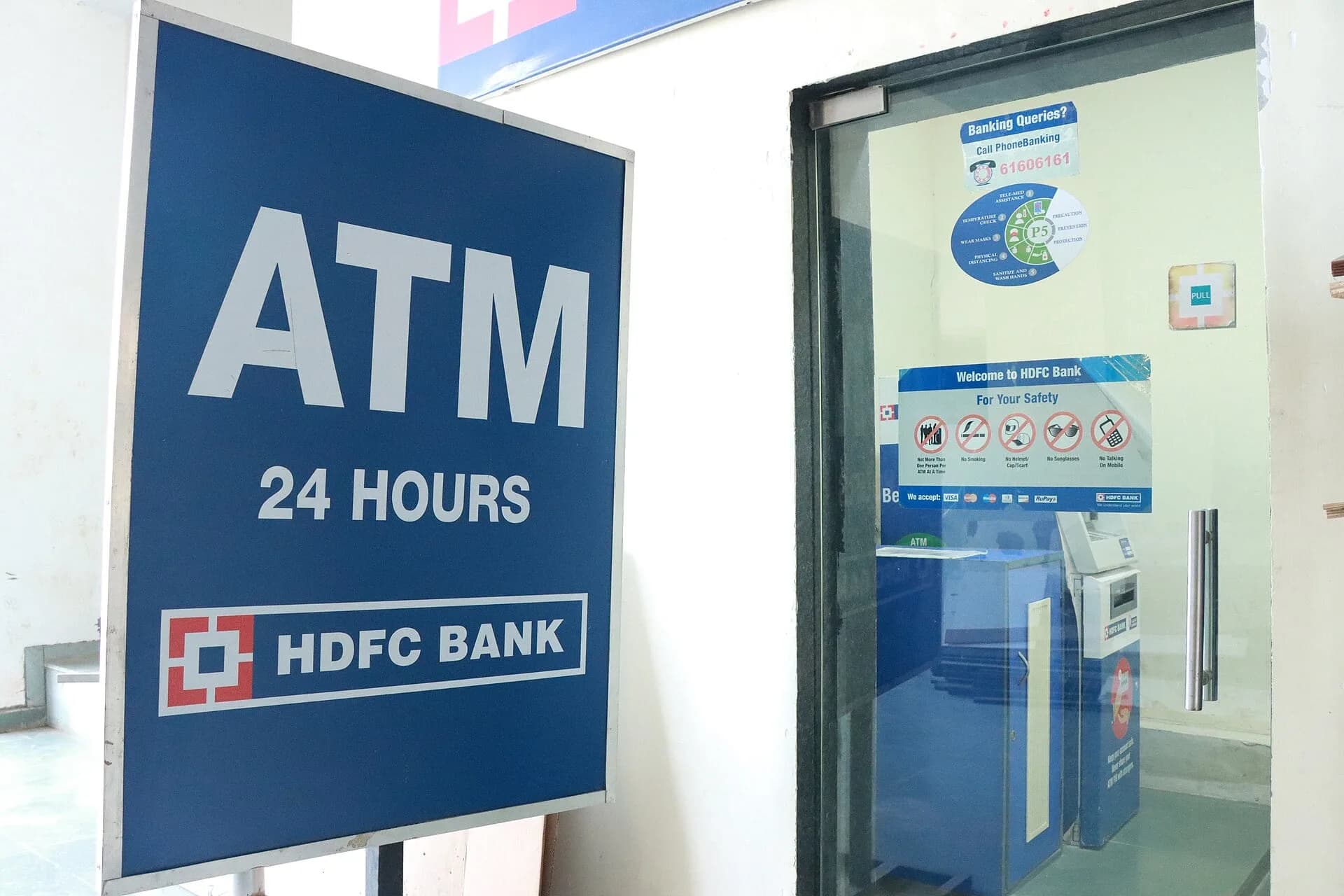 A bank ATM kiosk with a 24-hour sign