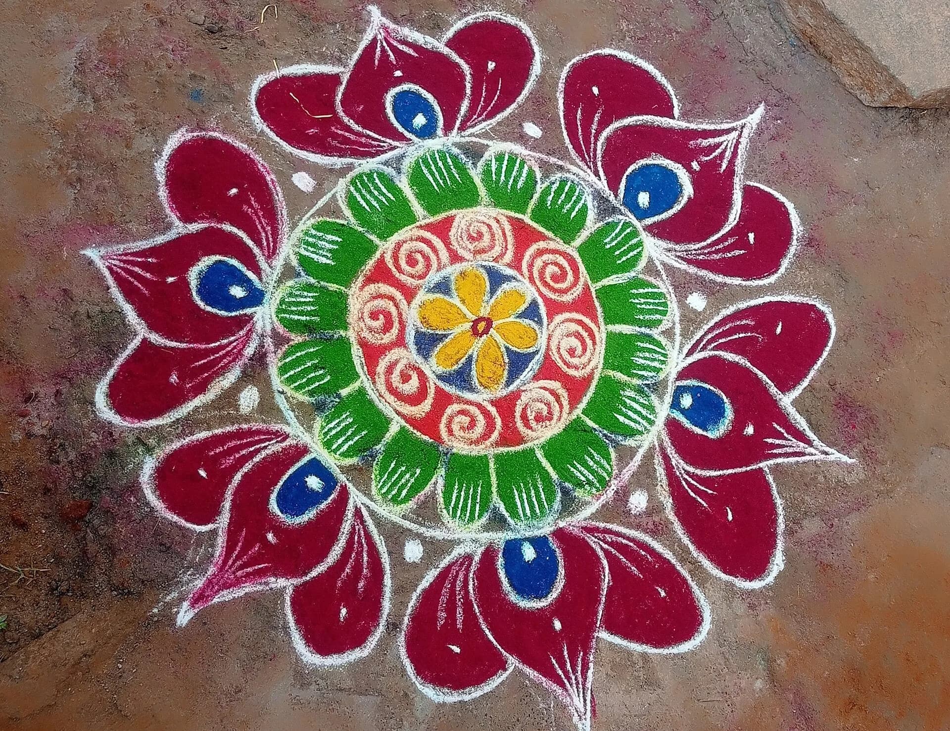A bright floral rangoli design on the floor