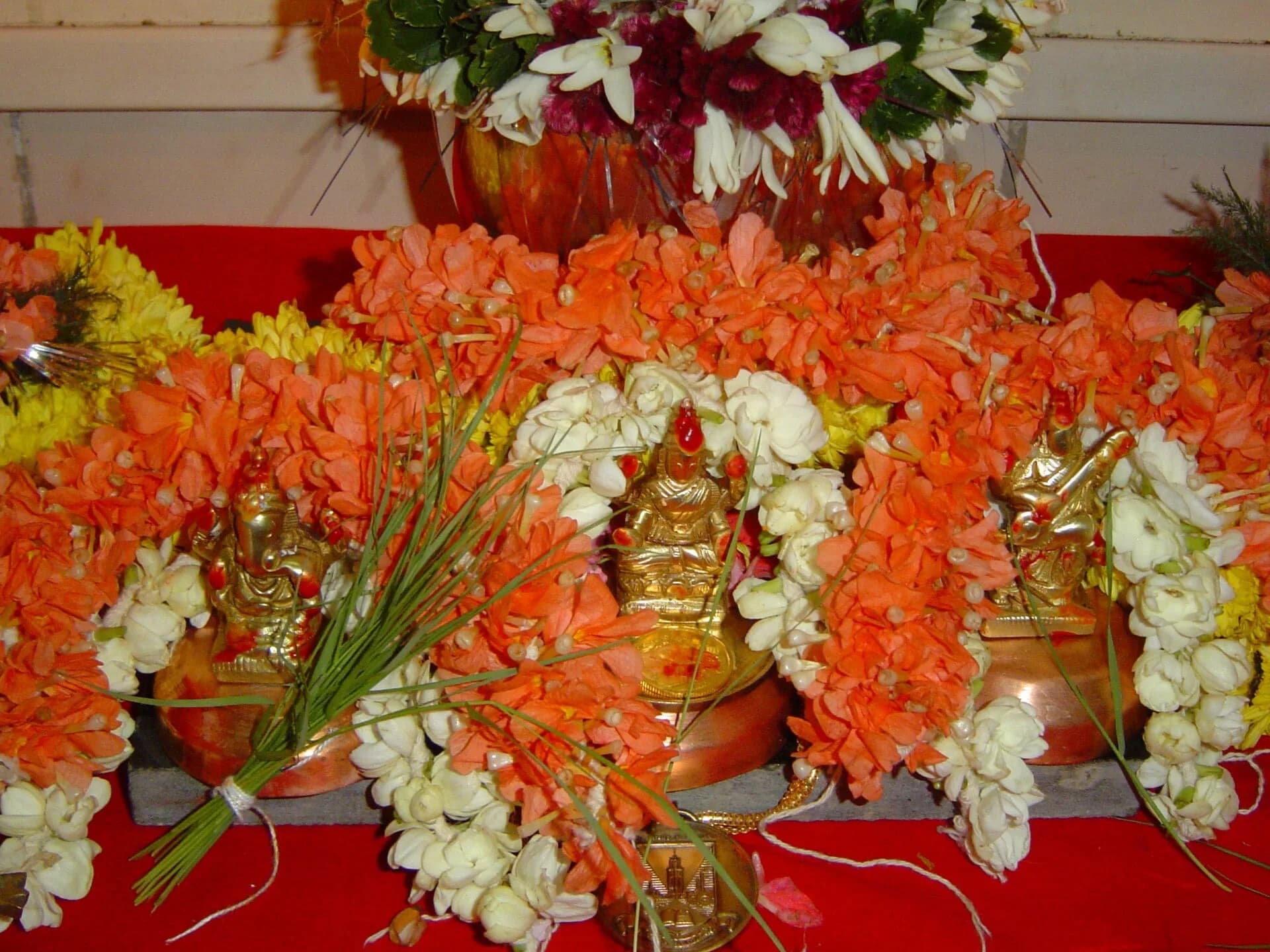 An altar decorated with orange and white flowers for a puja
