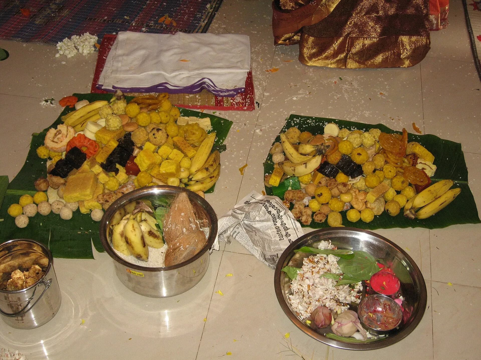 Plates of Indian sweets and fruit laid out for a celebration