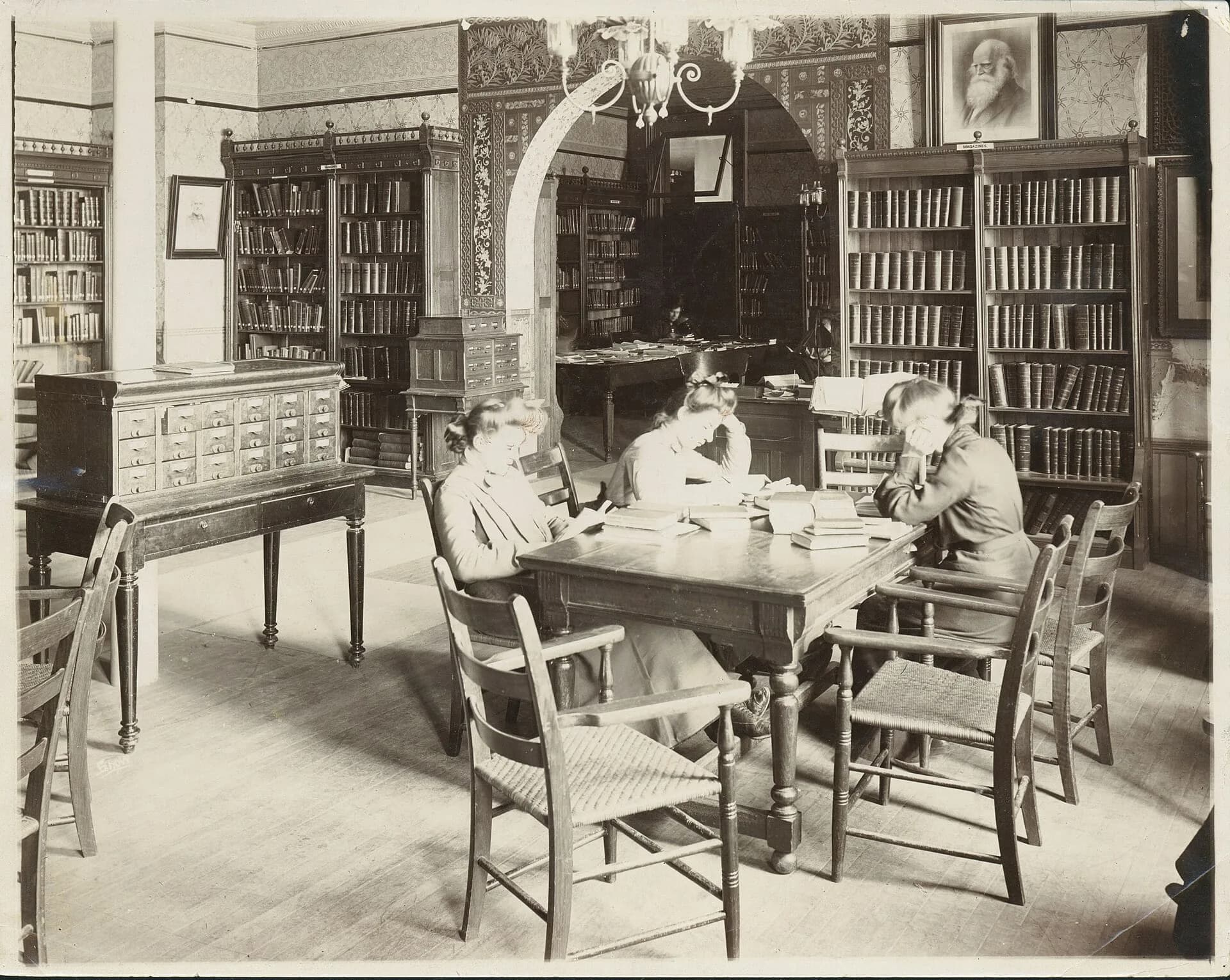 Three students studying together in a library