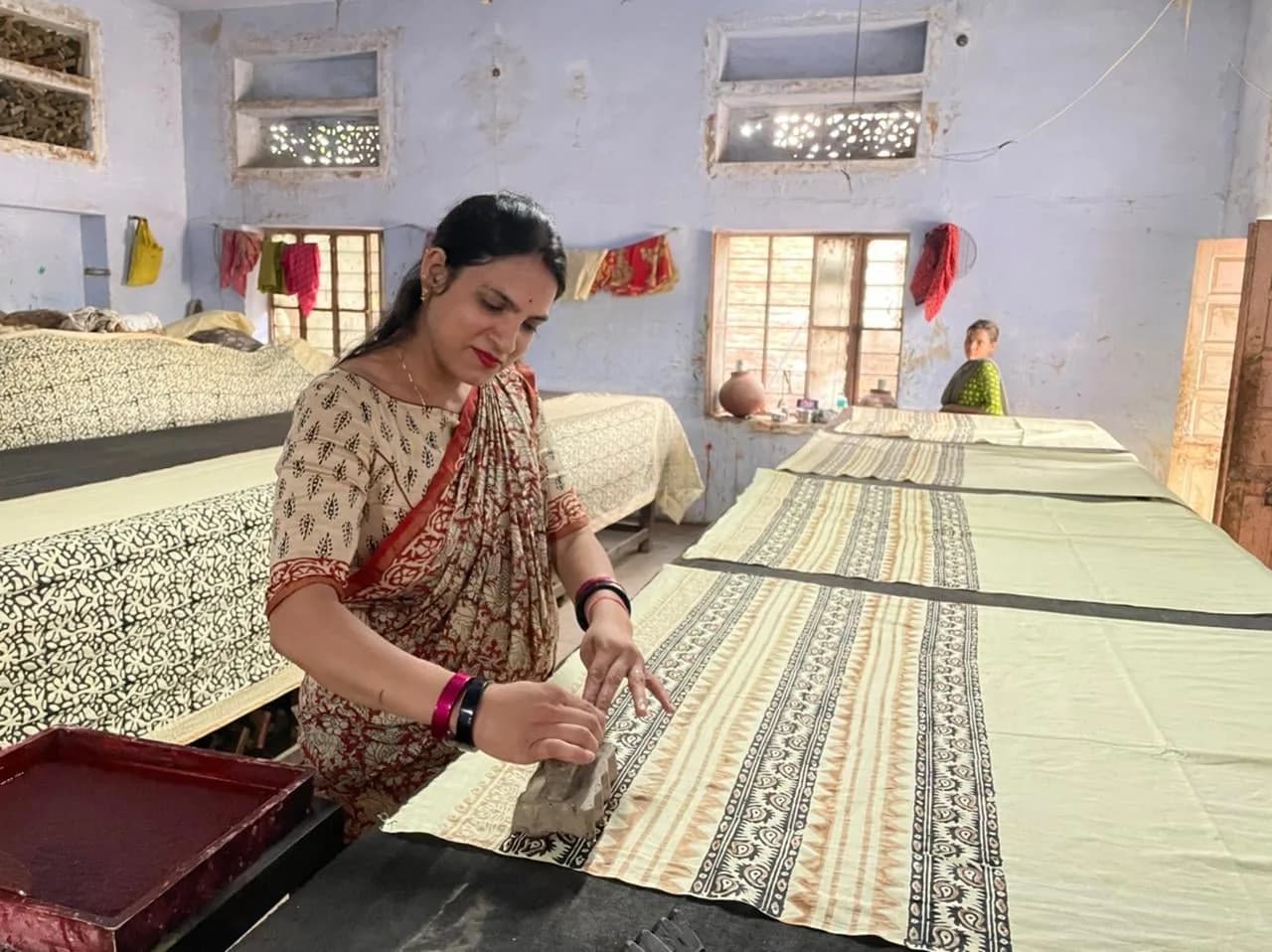 A woman hand block printing fabric in Bagru, Rajasthan