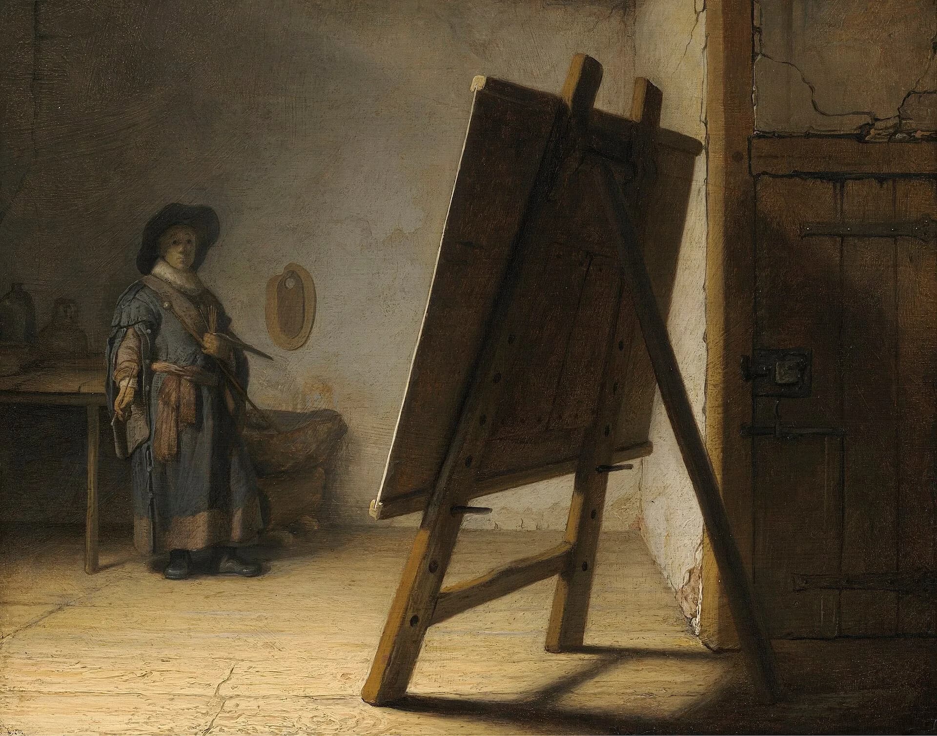 A painter at his easel in a studio, in a painting by Rembrandt