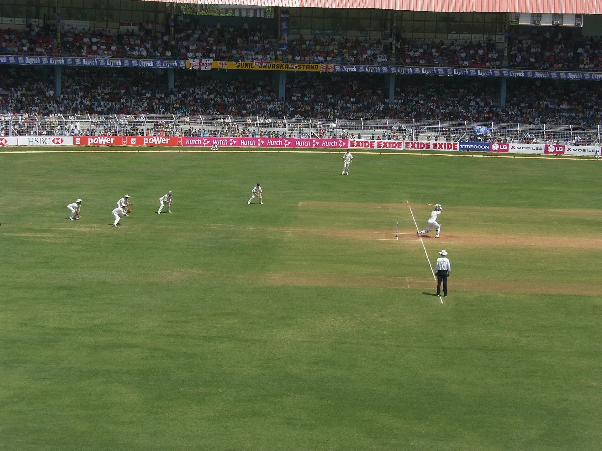 A cricket match in progress in a large Indian stadium