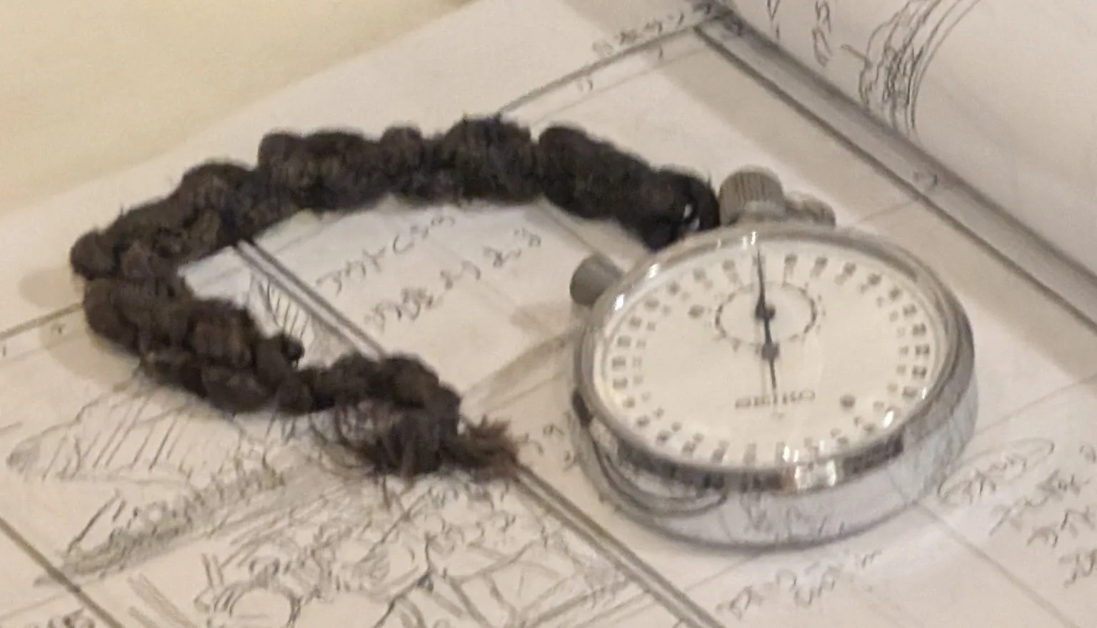 A silver stopwatch lying on a desk