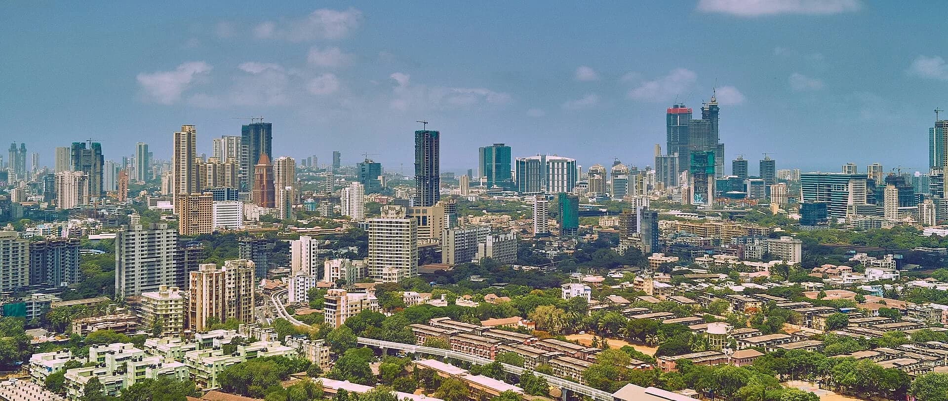 A wide view of the Mumbai skyline with high-rise towers above the city