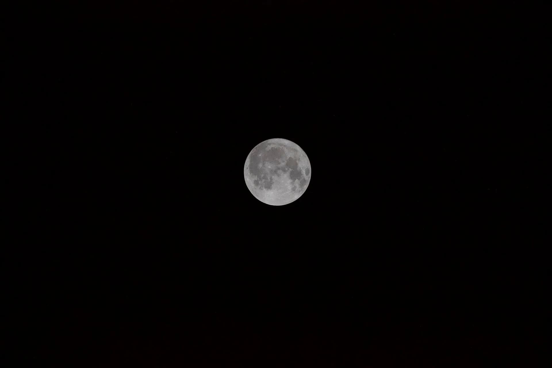 A full moon in a dark night sky