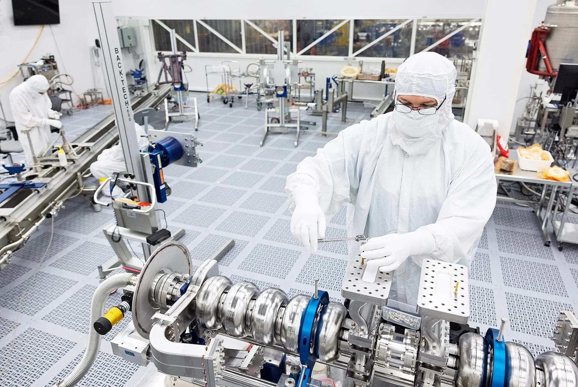 Workers in protective suits inside a semiconductor clean room