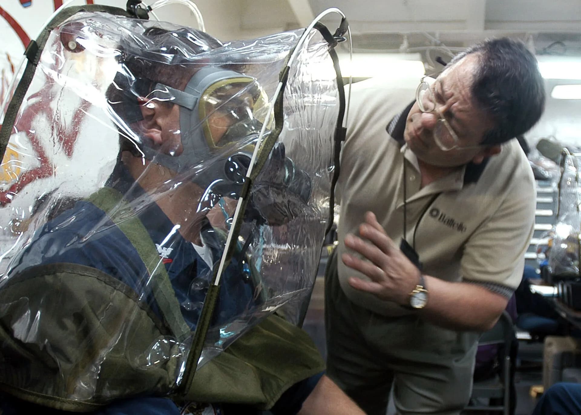 Technicians checking the fit of a mask on a sailor