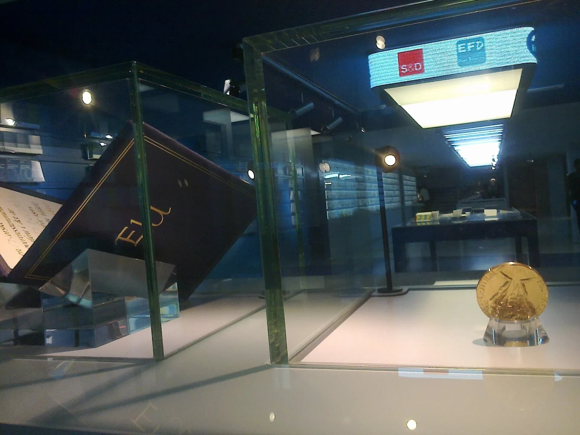 A museum display case with a gold medal