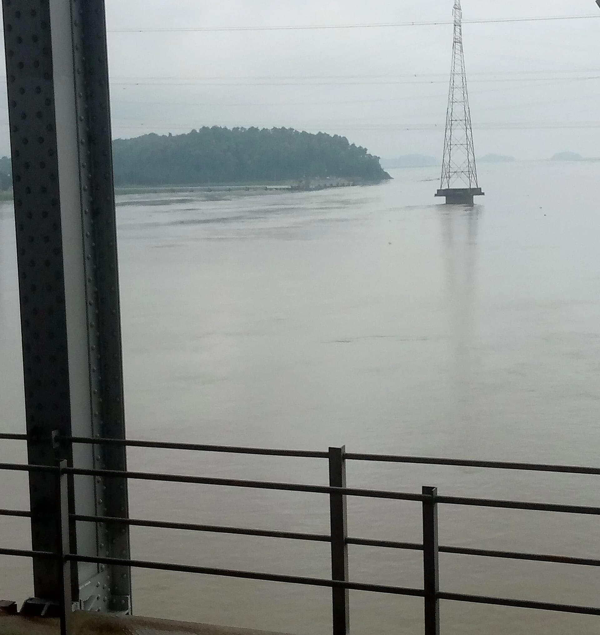 The wide Brahmaputra river seen from a train window