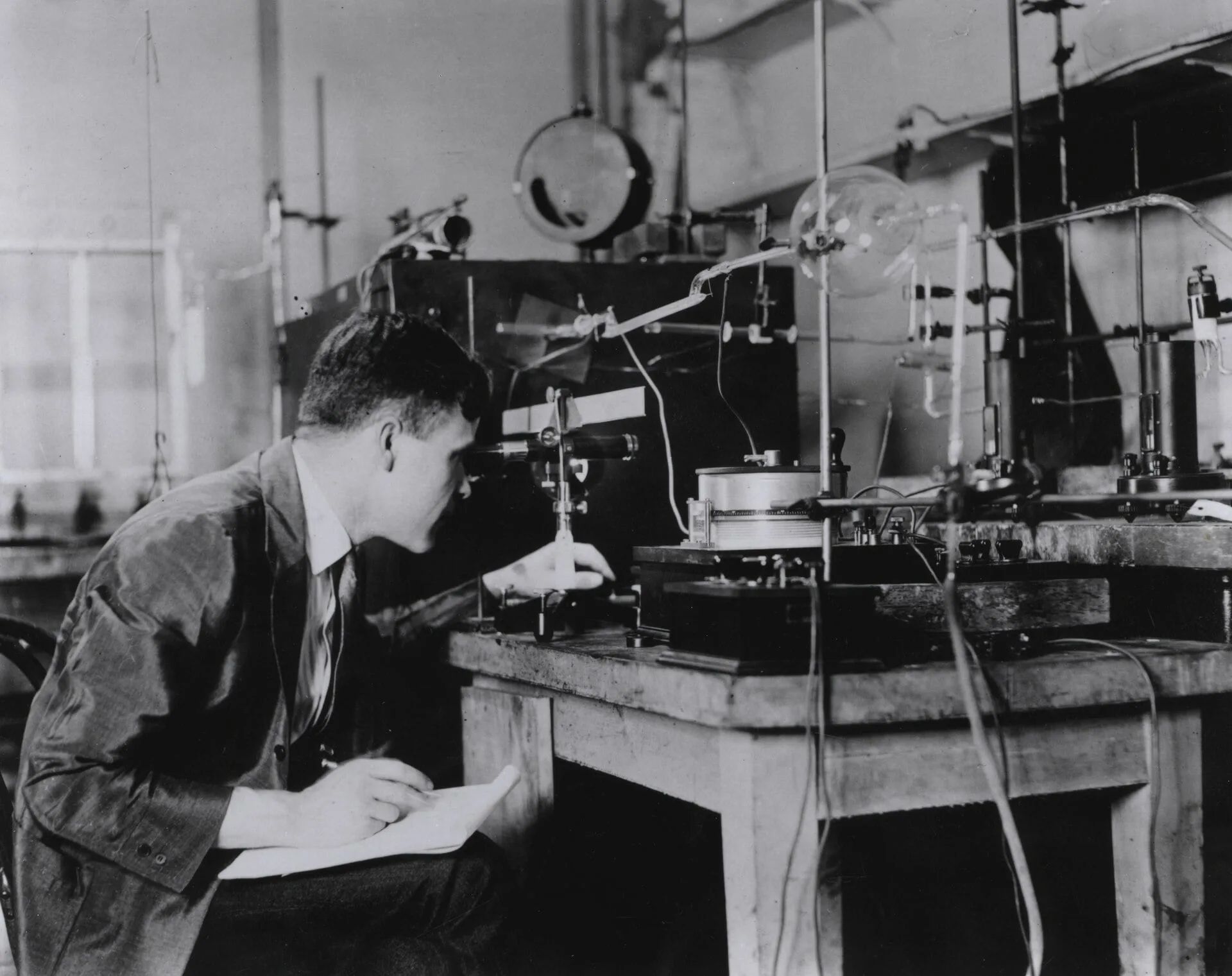 A black-and-white photograph of a scientist measuring thermal conductivity in a laboratory