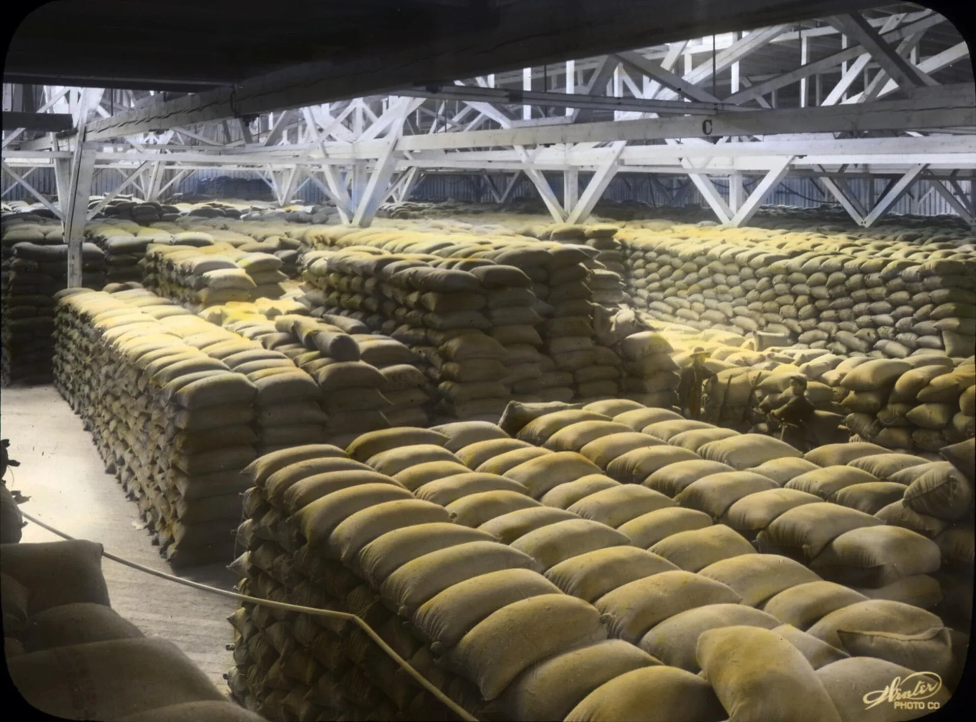 Sacks of grain stacked in a large warehouse