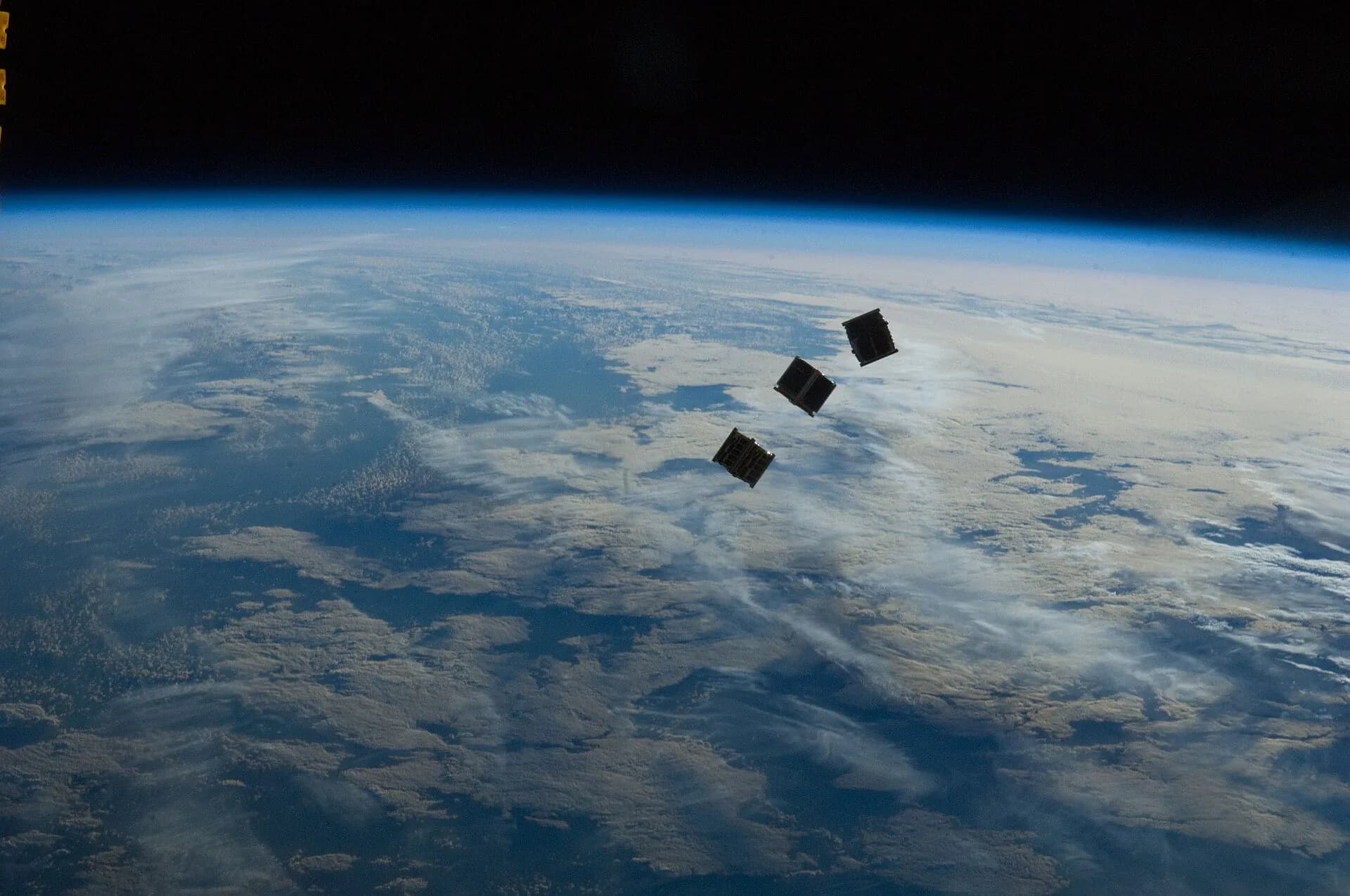 Small cube-shaped satellites drifting above the Earth