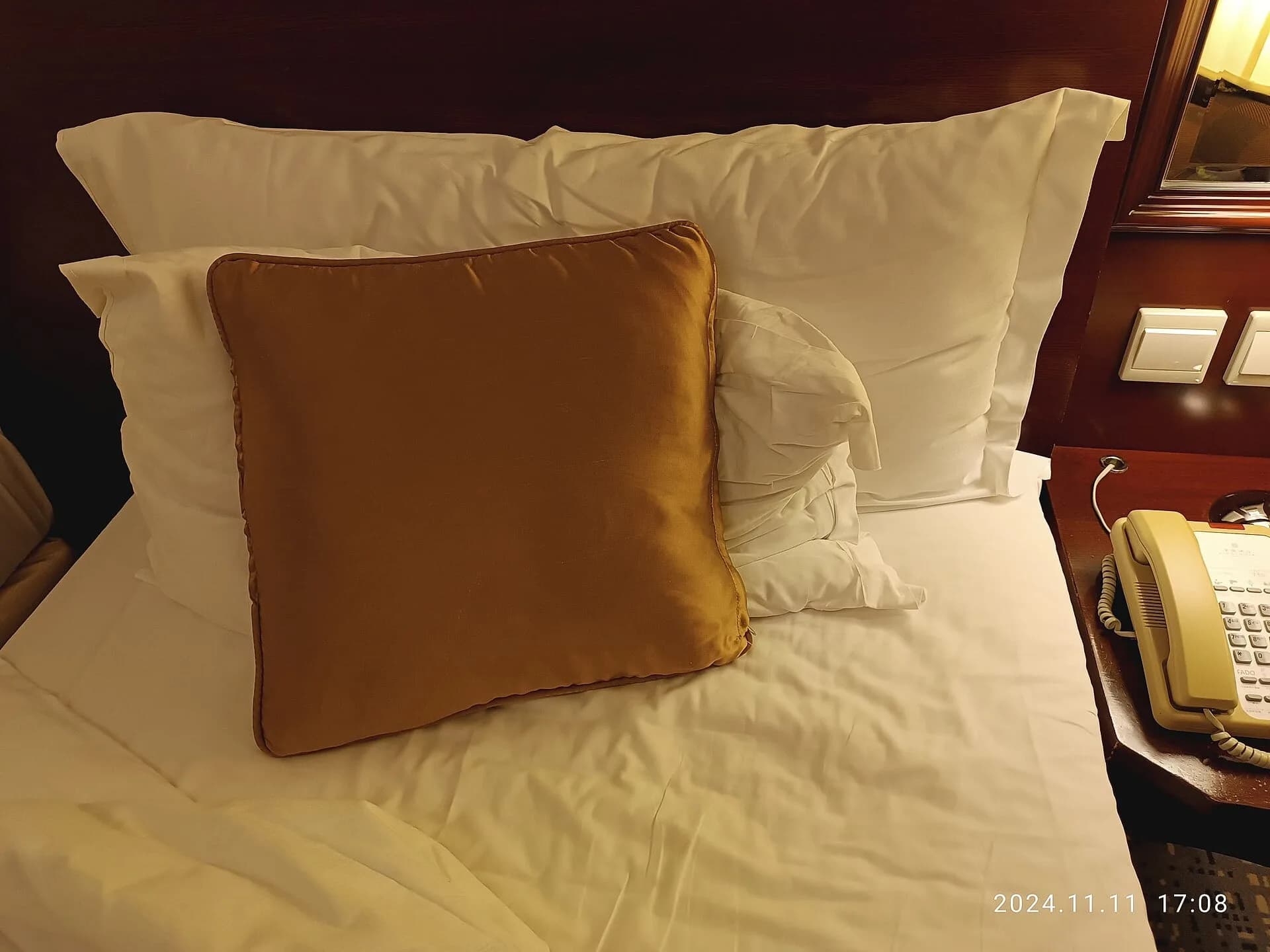 A neatly made bed with white sheets and soft pillows