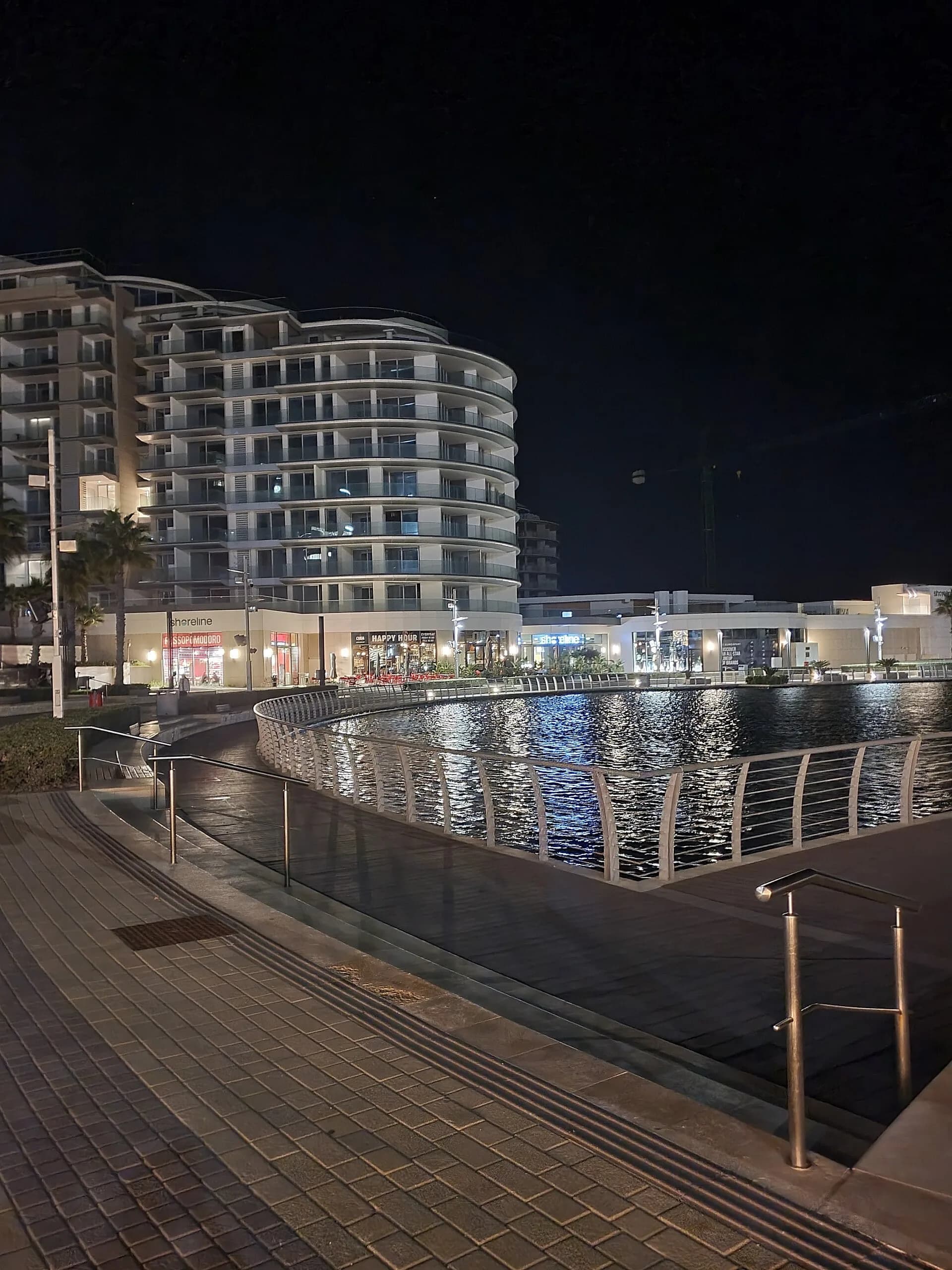 A modern city street lit up at night with buildings and lights