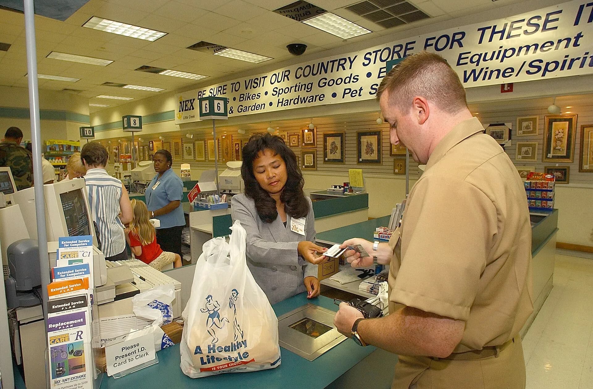 A shopper paying for goods at a store checkout counter