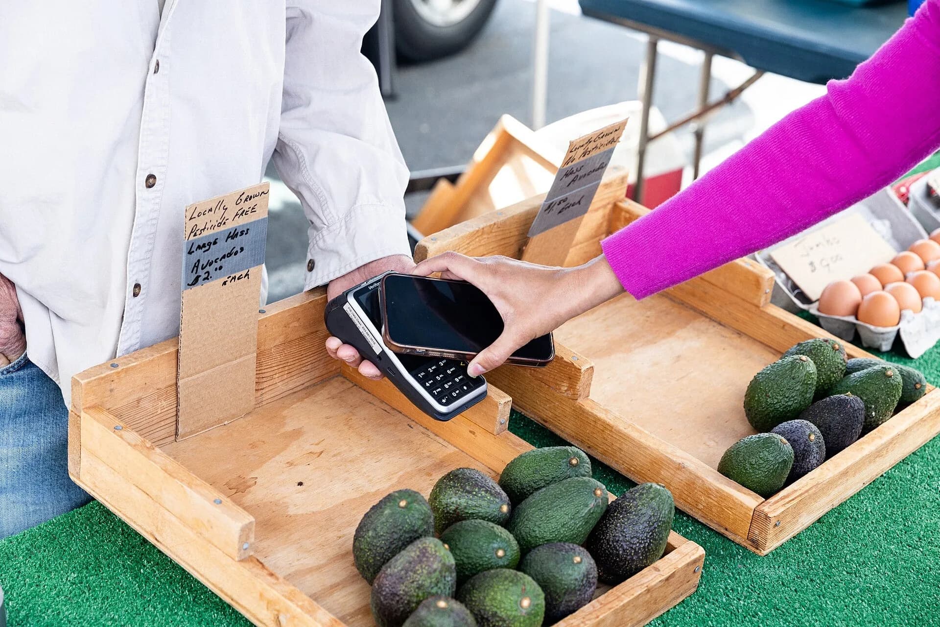 A customer paying with a mobile phone at a market stall