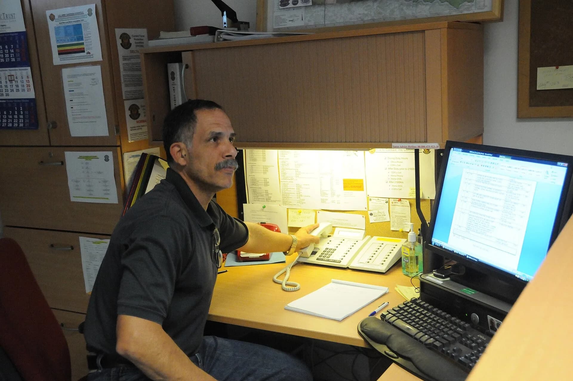 A man working at a computer at a desk in an office