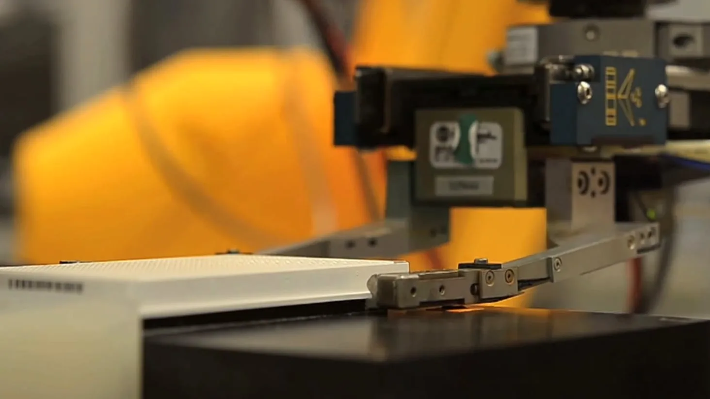 A robot arm handling a laboratory assay plate